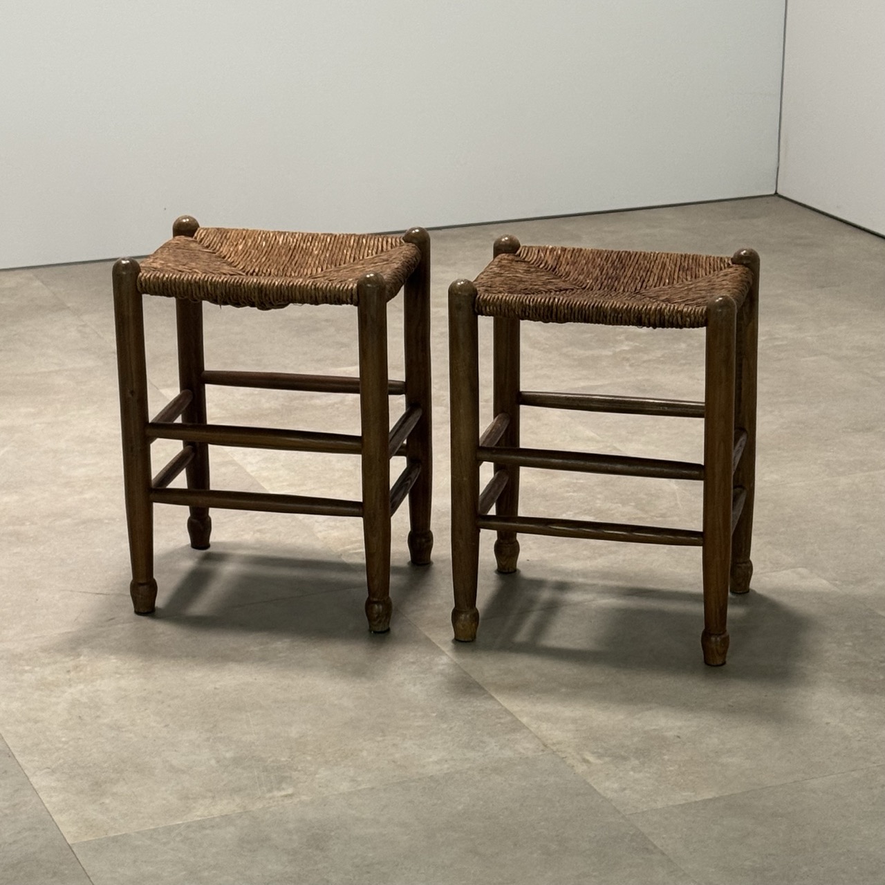 A set of two vintage oak stools with rush seats, France 1940's.